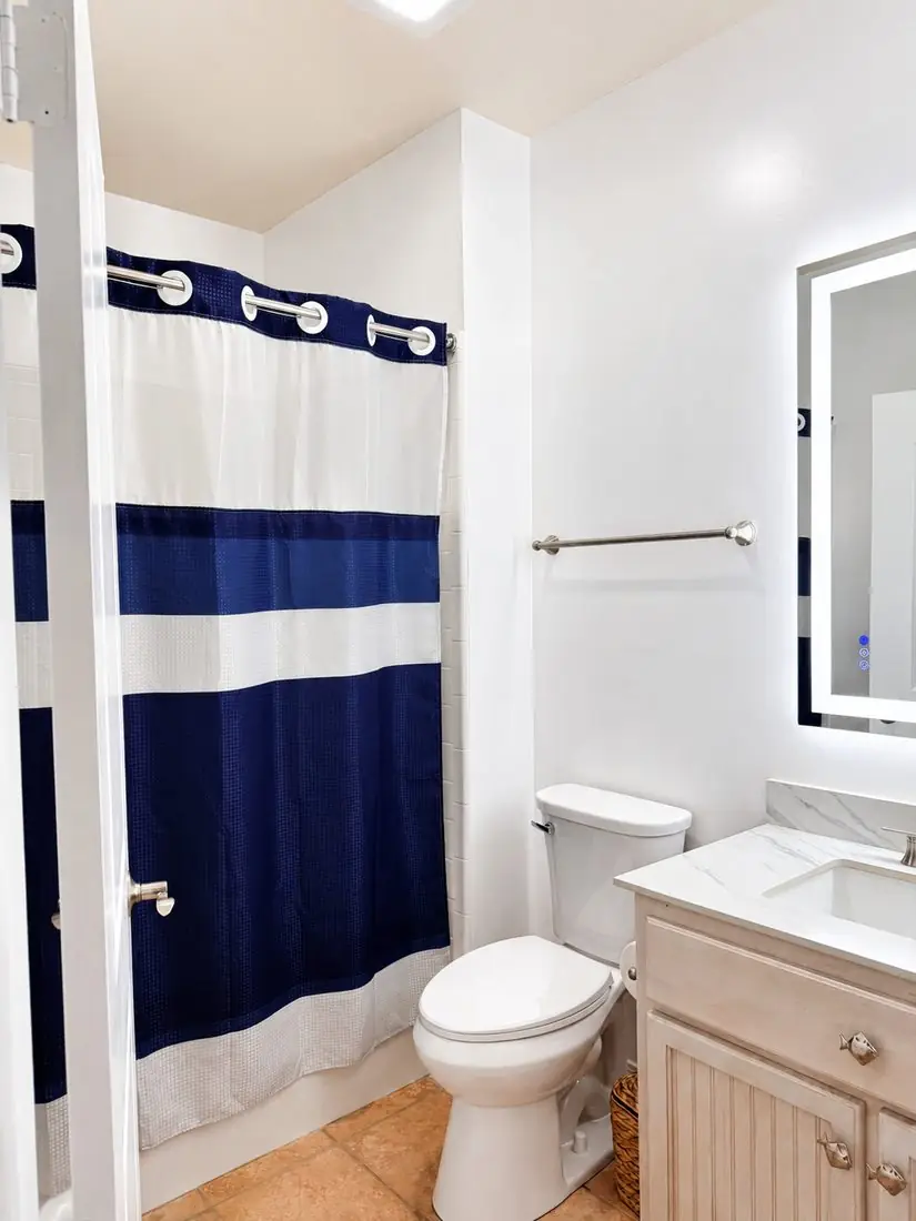 Full bathroom with navy shower curtain and tile flooring