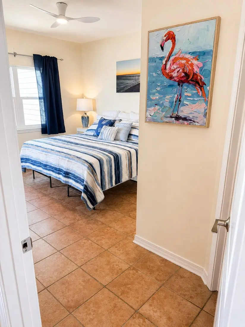 Hallway view into the primary bedroom with flamingo artwork
