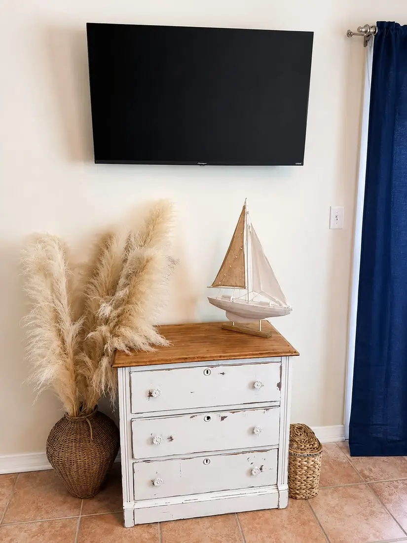Den with TV, dresser, and nautical sailboat decor